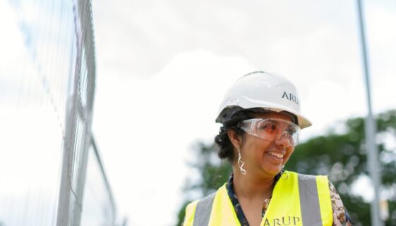 photo of female engineer wearing hard hat and yellow vest