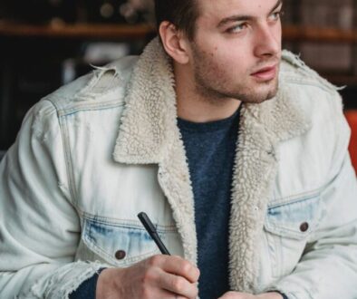 thoughtful man writing notes in notepad