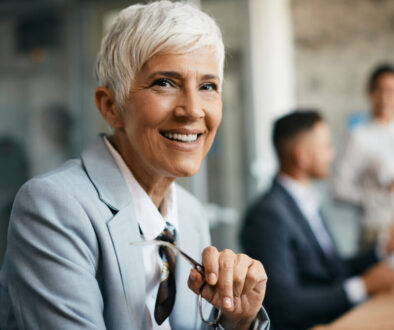 Portrait of happy mature businesswoman at corporate office looking at camera.